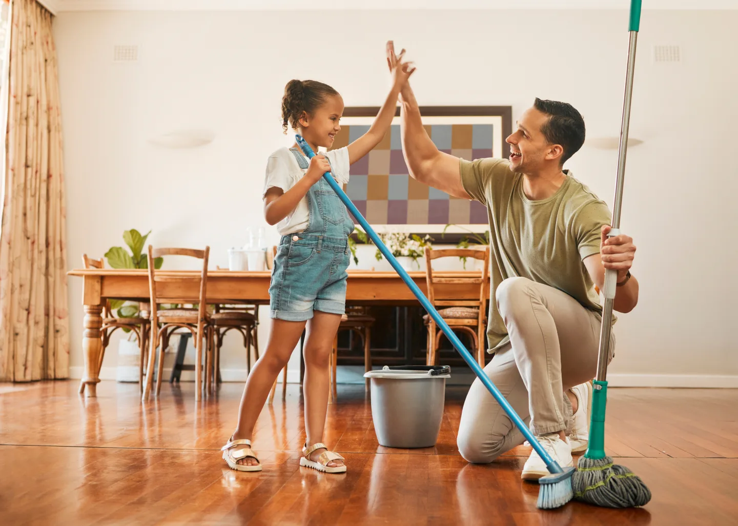 Dad high fiving daughter after she completes a chore