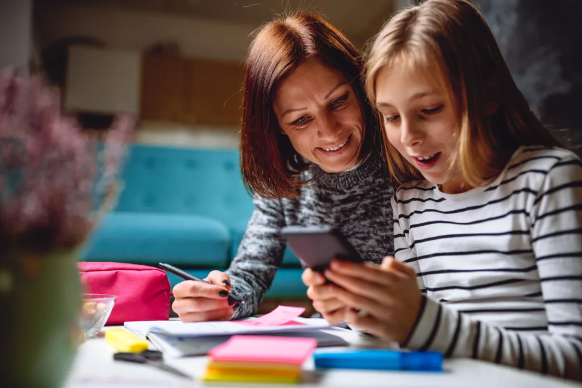 Mother and daughter reviewing chores on a phone