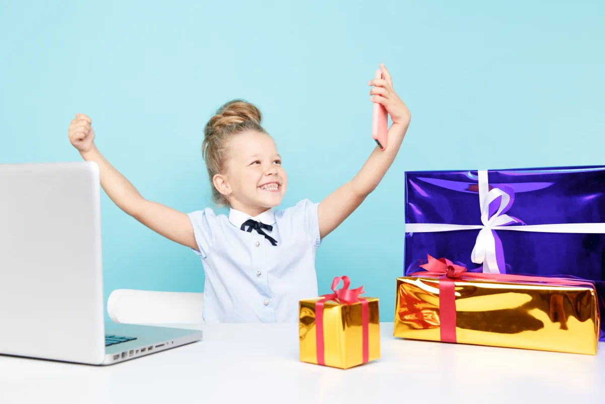 Child holding a device and present after earning a chore reward